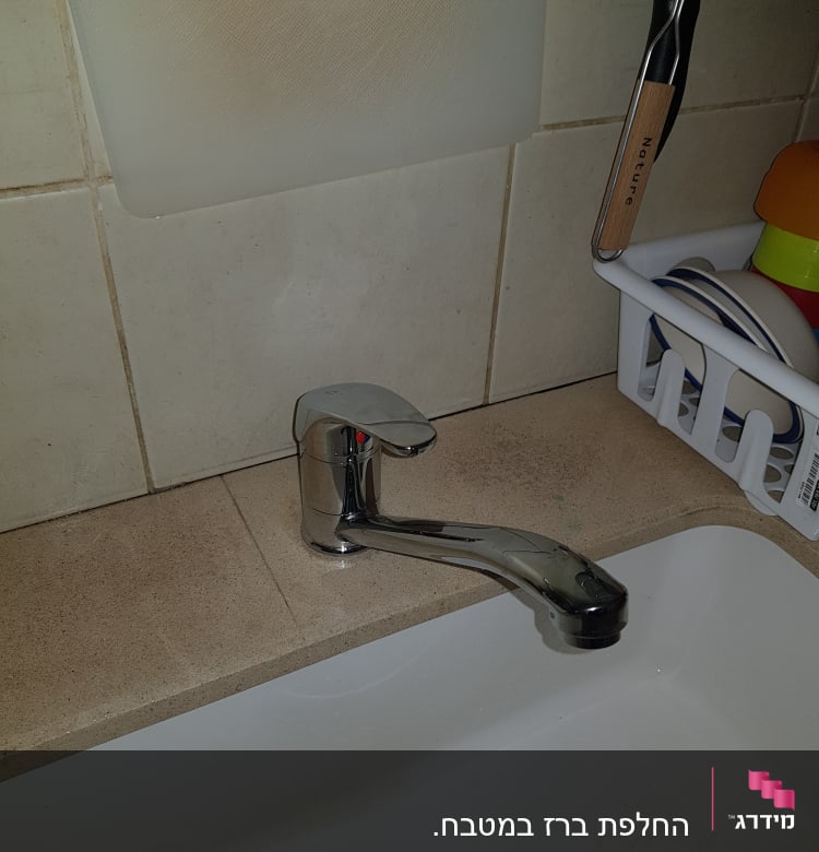 ברז כרום מותקן מעל כיור מטבח לבן